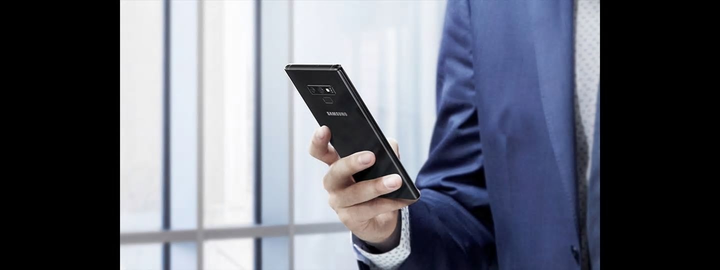 Image of man holding Galaxy Note9 during the day
