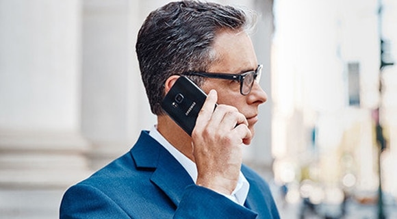 A businessman talking on a Samsung smartphone