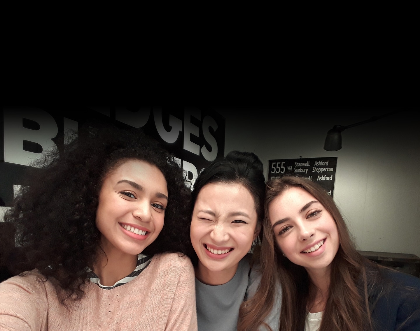 Selfie image of three women taken in low-light to show the advanced camera functionality of the Galaxy A3 (2017).