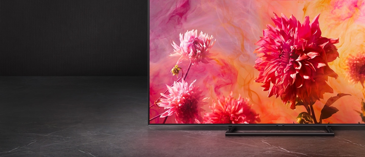 고급스러운 배경 위로 QLED TV가 정면으로 놓여져 있고, 화면 안에는 따뜻하고 화려한 색감의 꽃들이 보여집니다.