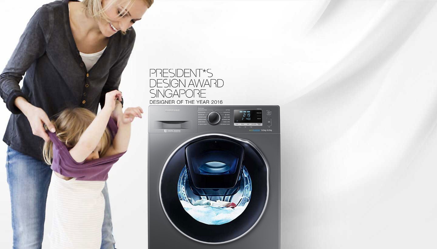 An image of a woman taking off her child's clothes next to a WW8500 washing machine which is in the middle of a cycle.