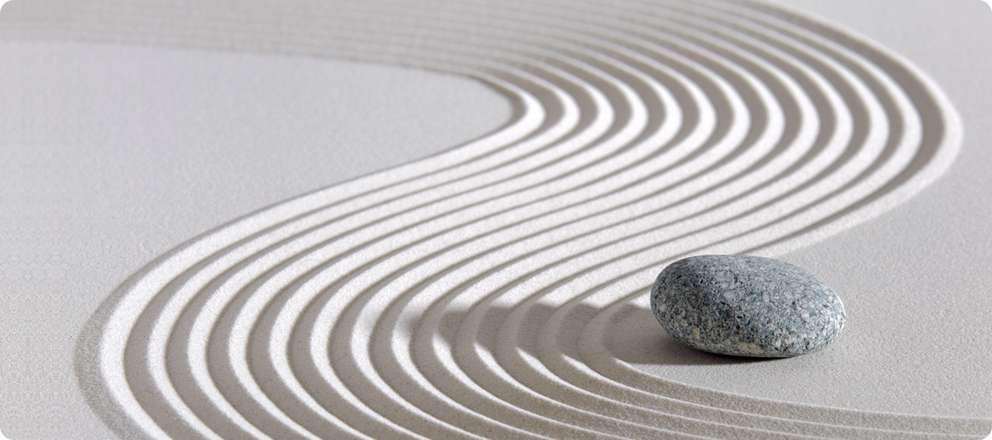 기하학적인 문양이 그려져 있는 모래 위에 돌이 놓여 있습니다.