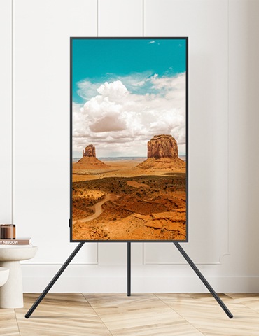 벽걸이 TV가 세로모드로 설치되어있고, 화면에는 붉은 사막 모습이 보입니다.