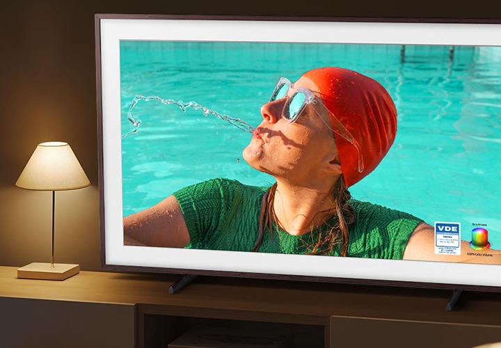 TV 화면에 수영장에 가슴까지 걸치고 있는 여자가 보이며, 우측으로 컬러볼륨 인증 로고가 하단에 배치되어 있습니다.