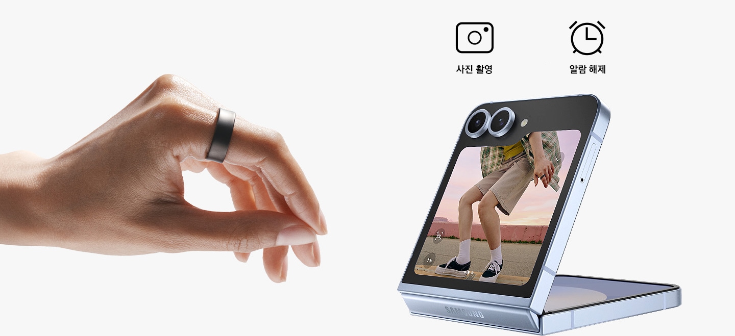 갤럭시 링을 착용한 손이 있고 손가락으로 꼬집는 듯한 동작을 하고 있습니다. 카메라가 열린 갤럭시 Z 폴드6가 접혀져 있습니다. 스마트폰 위에 2개의 아이콘이 있고 각각 카메라 앱과 알람 끄기입니다.