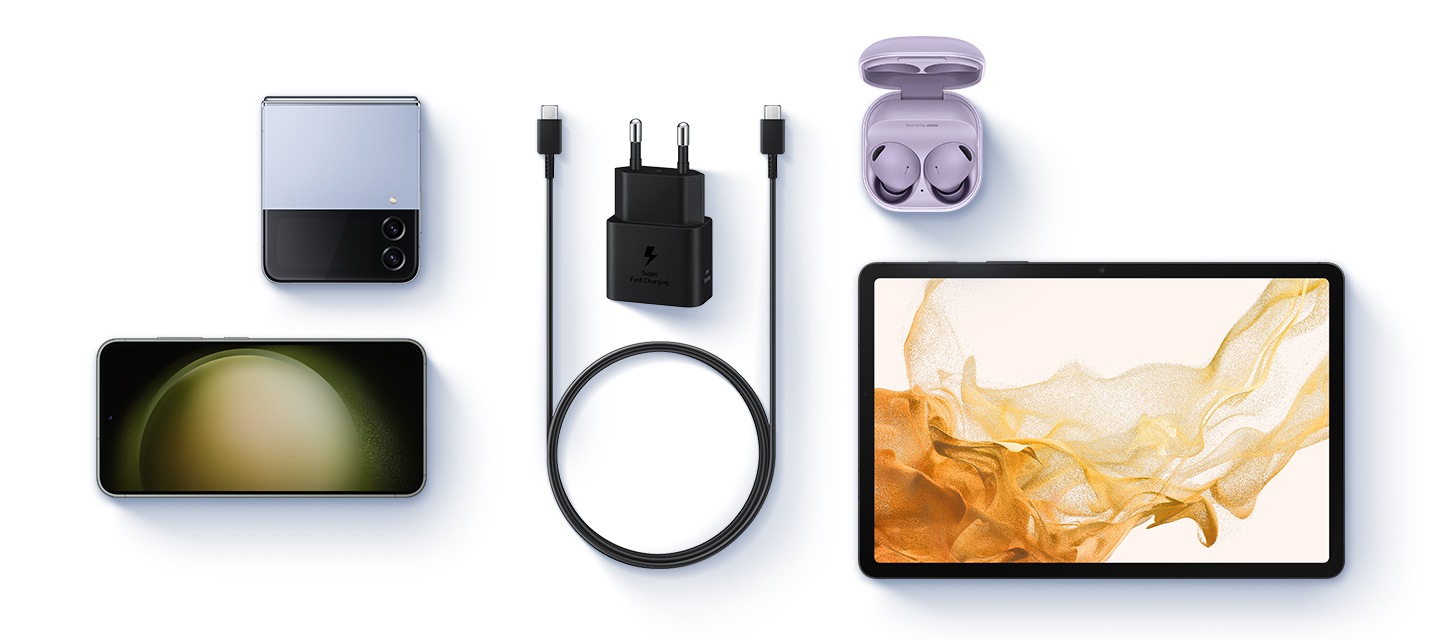 충전기가 중앙에 있으며 아래에 USB C to C의 케이블이 보여집니다. 왼쪽 상단에는 갤럭시 Z 플립이 보여지며 왼쪽 하단에는 갤럭시가 보여집니다. 오른쪽 상단에는 갤럭시 버즈가 보여지며 오른쪽 하단에는 갤럭시탭이 보여집니다.
