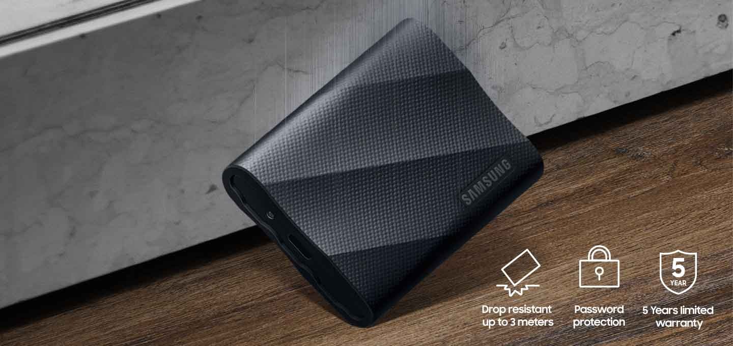 나무 바닥에 외장 SSD T9 USB 제품이 떨어지고 있는 이미지와 이미지 오른쪽 하단에 왼쪽에서 순서대로 Drop resistant up to 3 meters 텍스트와 제품을 떨어뜨려 충격이 간 아이콘, password protection 텍스트와 자물쇠 아이콘, 5 years limited warranty 텍스트와 방패 모양의 아이콘 안에 5 years 텍스트가 적혀있는 아이콘이 있습니다.