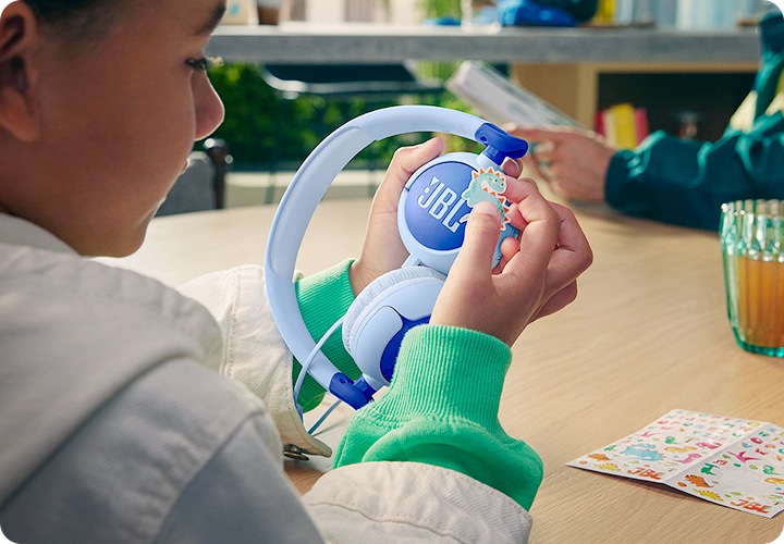 여자아이가 제품에 스티커를 붙이고 있습니다.