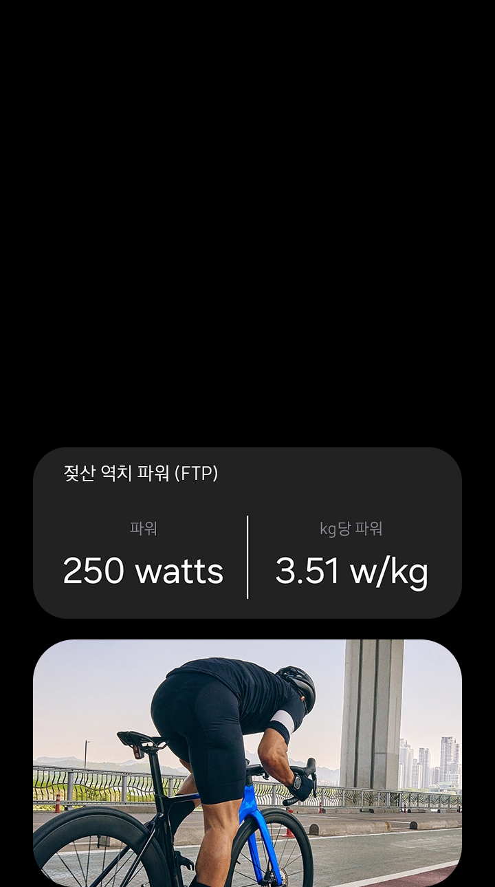 FTP 통계를 보여주는 카드에 젖산 역치 파워 (FTP)에 대한 설명으로 파워 '250 watts', kg 당 파워 '3.51 w/kg' 문구가 보여집니다. 도로 경주용 자전거를 탄 남성이 자전거 도로를 따라 이동하고 있습니다.