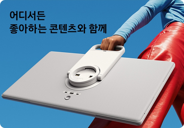 여성이 스탠드에서 분리된 The Movingstyle을 들고 이동하고 있습니다. 좌측 상단에는 '어디서든 좋아하는 콘텐츠와 함께' 문구가 기재되어 있습니다.