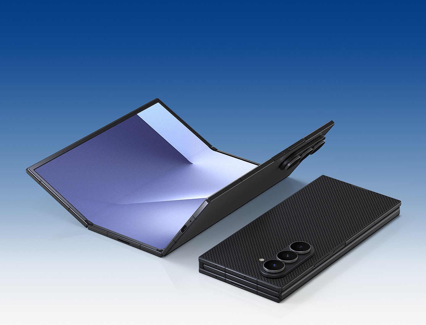 두 대의 갤럭시 Z 트라이폴드가 나타납니다. 하나는 메인 디스플레이를 위로 향한 채 거의 펼쳐져 있고, 다른 하나는 완전히 접힌 채 후면의 크래프티드 블랙 색상을 강조합니다.