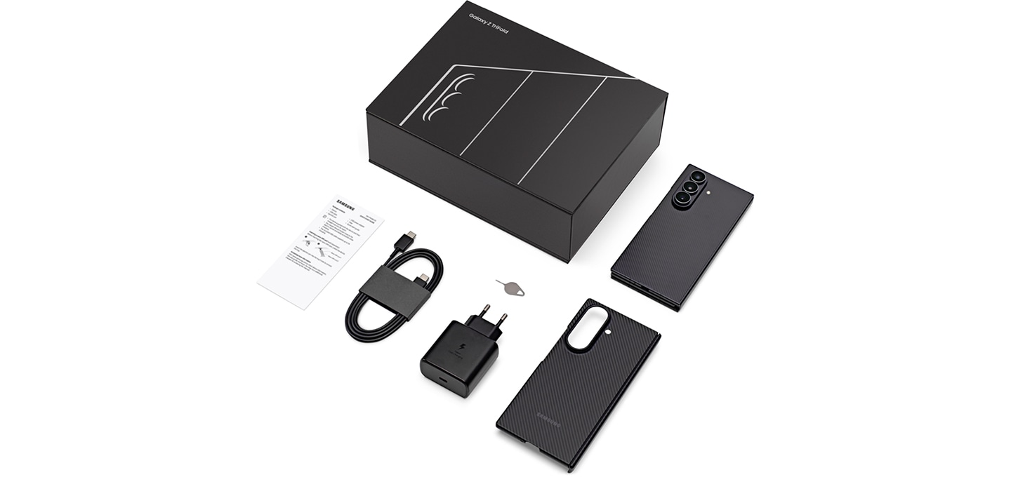'갤럭시 Z 트라이폴드 패키지에 포함된 기본 구성품들을 위에서 촬영한 장면입니다. 매트한 블랙 색상 패키지, 기기, 케이스, SIM 분리 핀, 45W 충전 어댑터, 데이터 케이블, 그리고 사용 설명서가 있습니다.