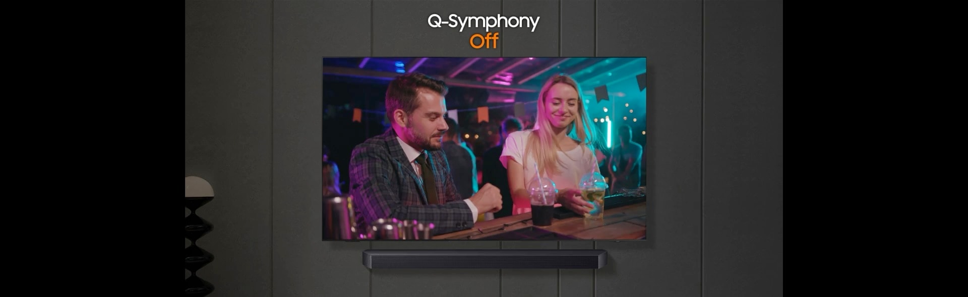 TV 화면에 남성과 여성이 식당에서 대화하는 장면이 표시됩니다. TV와 사운드바 위로 'Q-Symphony Off'라고 써 있습니다.