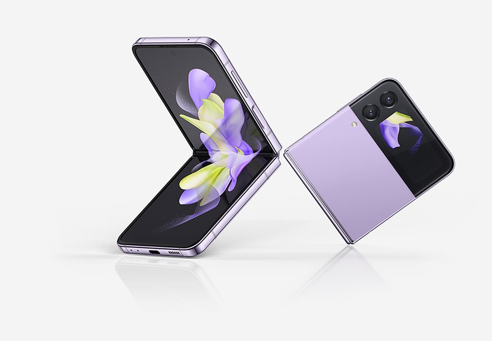 Two Bora Purple Samsung Z Flip4 devices are next to each other. One is open at a 90 degree angle and its Main Screen displays a purple and yellow ribbon-like wallpaper. The other is folded and its Cover Screen features the same wallpaper as the Main Screen on the other device.