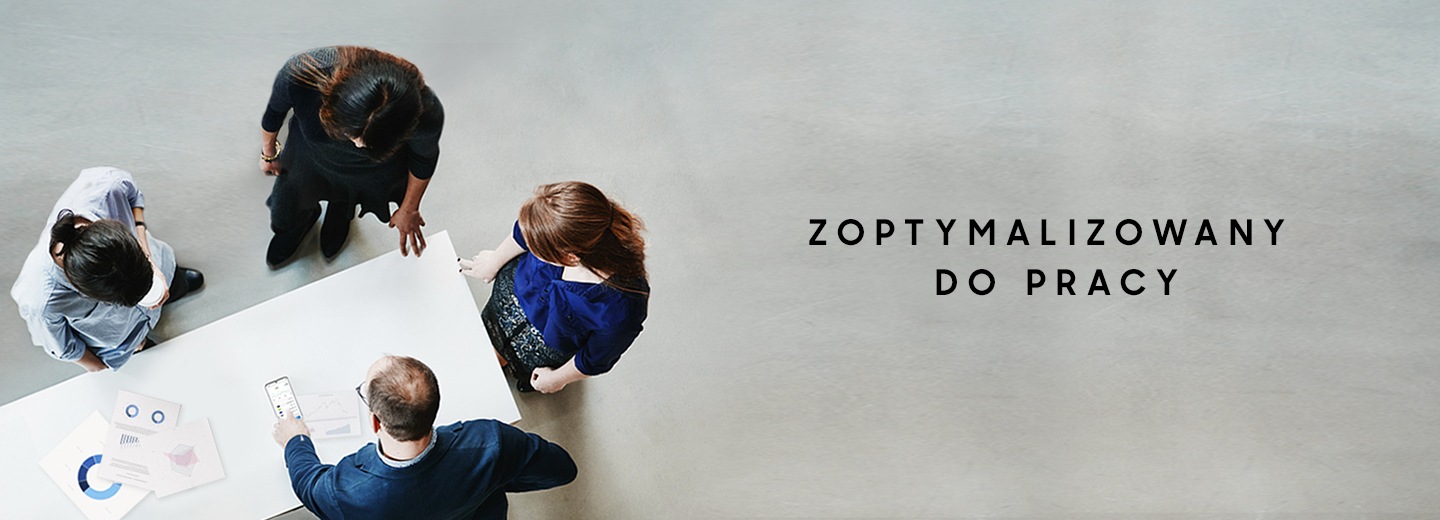Cztery osoby stoją wokół stołu, na którym leżą wykresy. Mężczyzna wskazuje na wyświetlacz smartfona Galaxy S20 Ultra, widać tekst, który mówi " Zoptymalizowany dla biznesu"