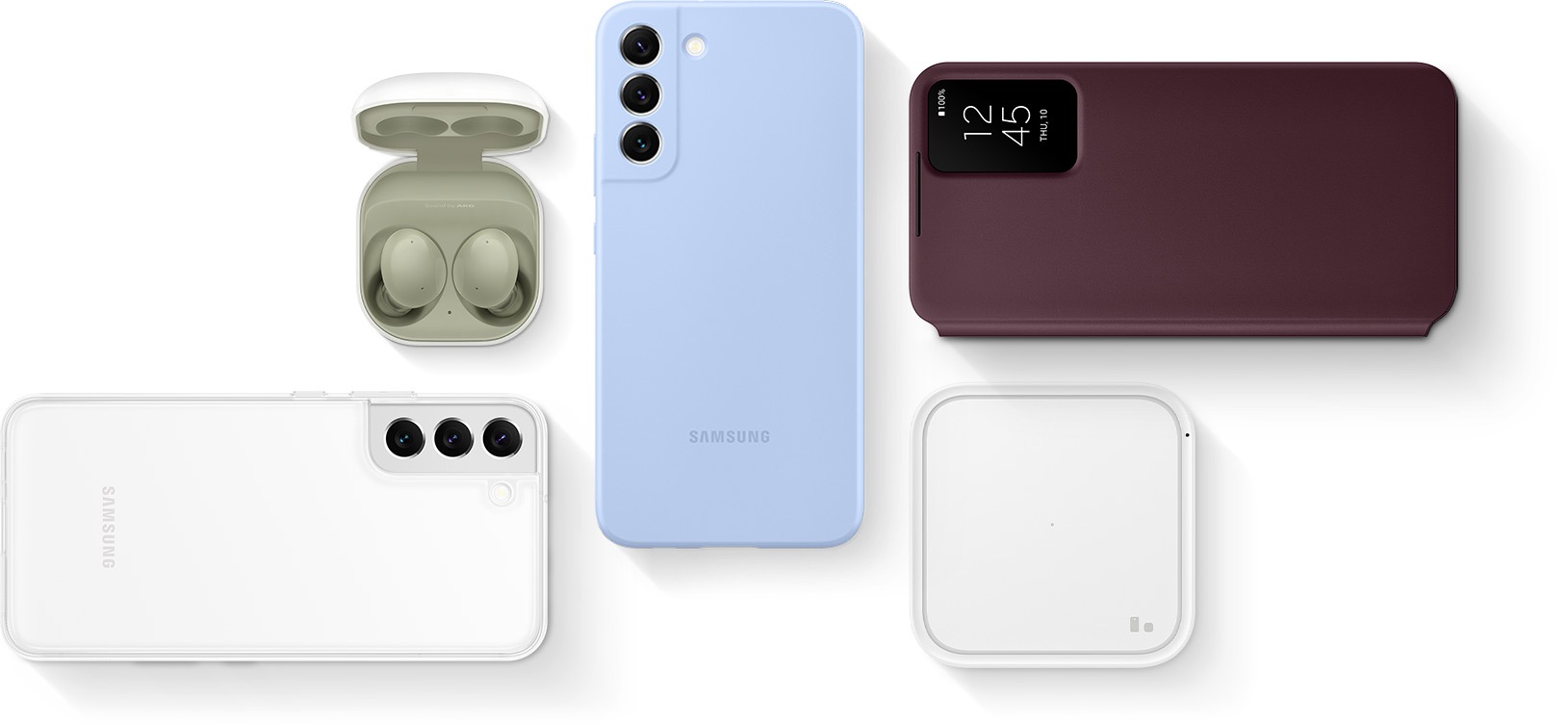 Flat lay of Super Fast Wireless Charger, Galaxy Buds2 with the cradle open and the earbuds in place, Galaxy S22 plus seen facedown with the Clear Cover installed, Galaxy S22 plus seen faceup with the Smart Clear View Cover installed and Galaxy S22 plus seen facedown with the Silicone Cover installed.