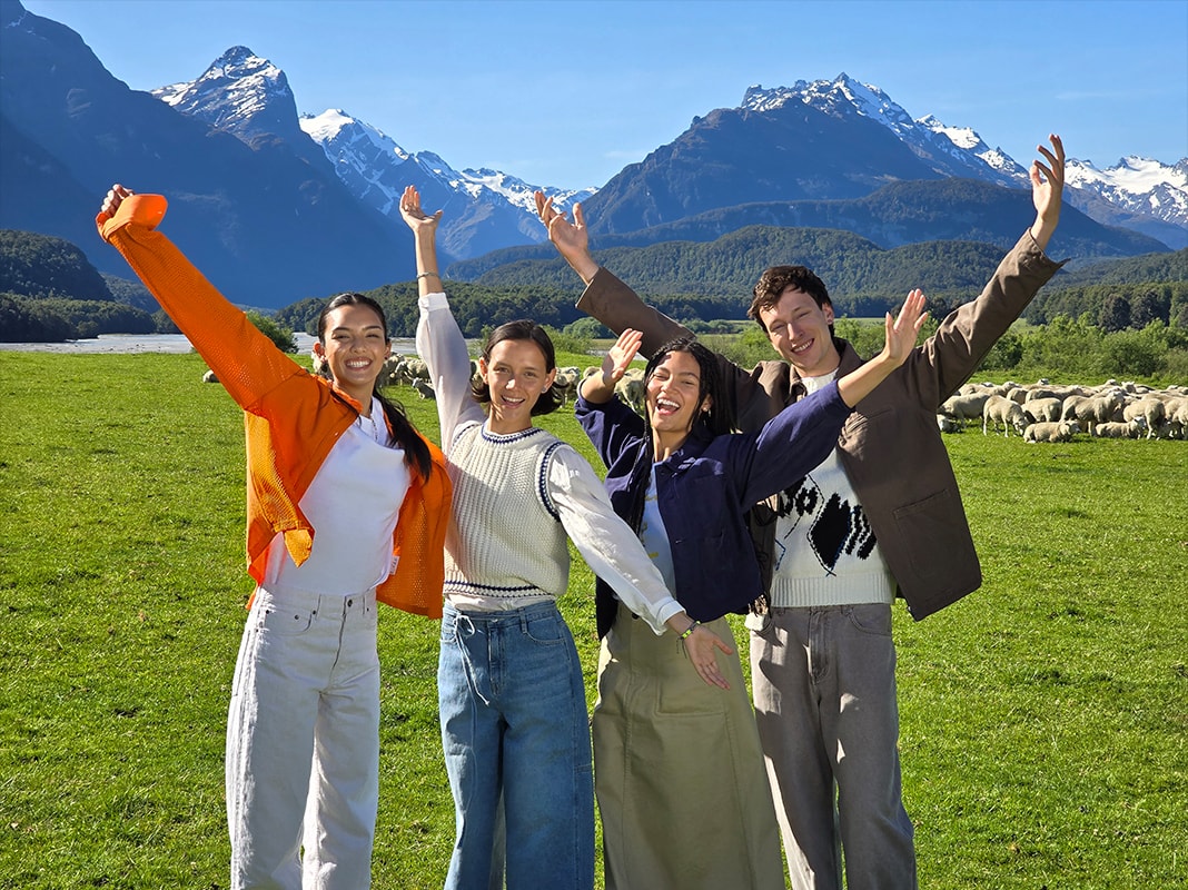 A photo of an open field and mountains with a group of friends in the foreground 3x optical zoom.