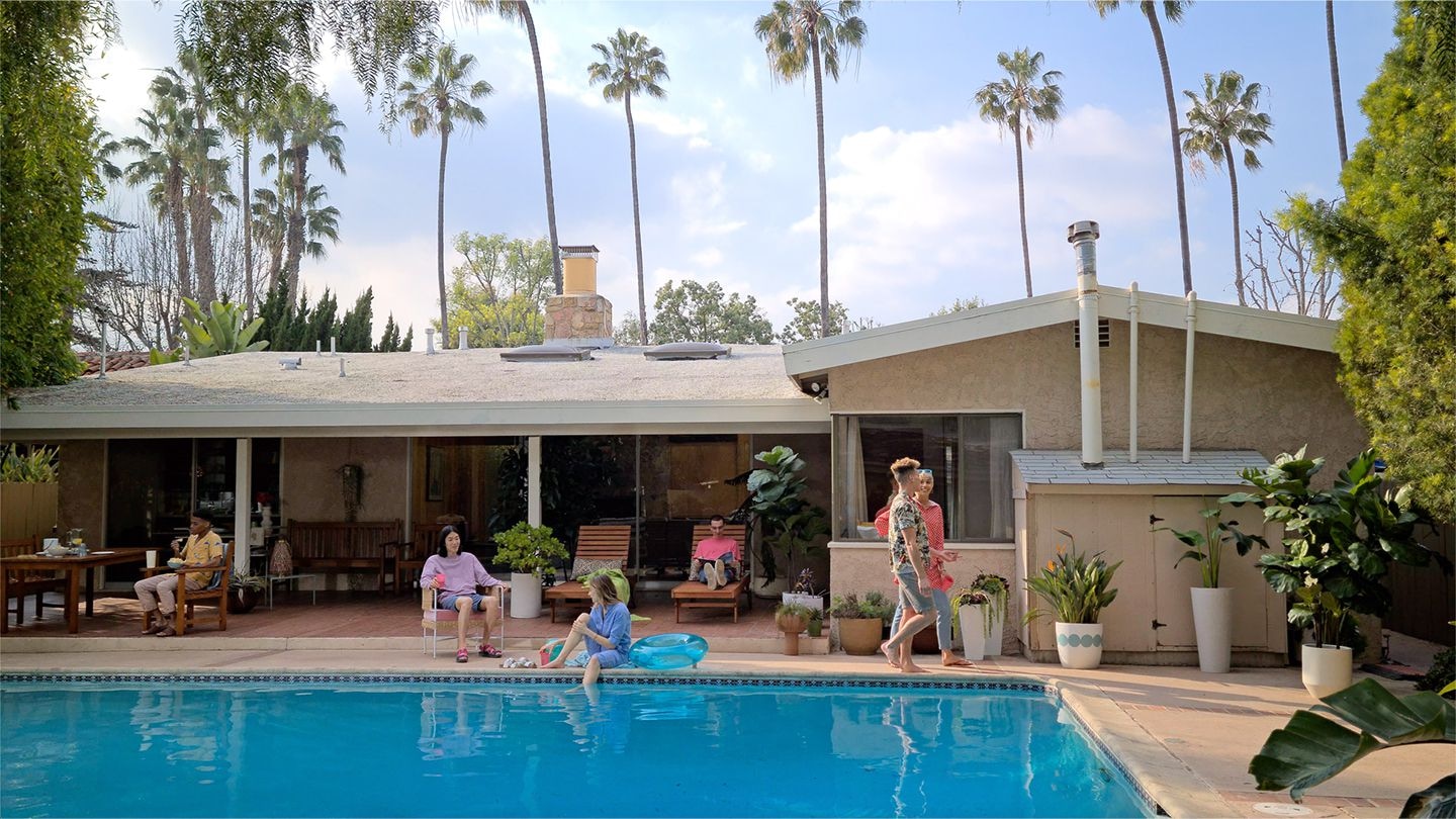 Des gens qui flânent au bord d’une piscine derrière une maison avec une interface de streaming superposée. La vidéo est fluide avec peu de décalage grâce à la connexion rapide