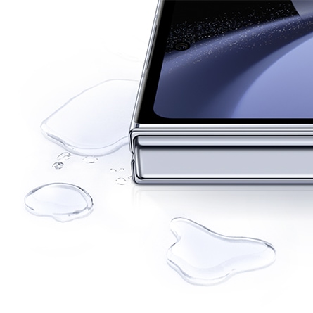 Gros plan sur un coin du Galaxy Z Fold5 avec des gouttelettes d’eau autour.
