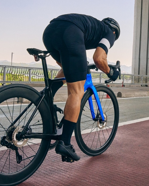 Un hombre con equipo de ciclismo anda en bicicleta por un sendero para bicicletas.