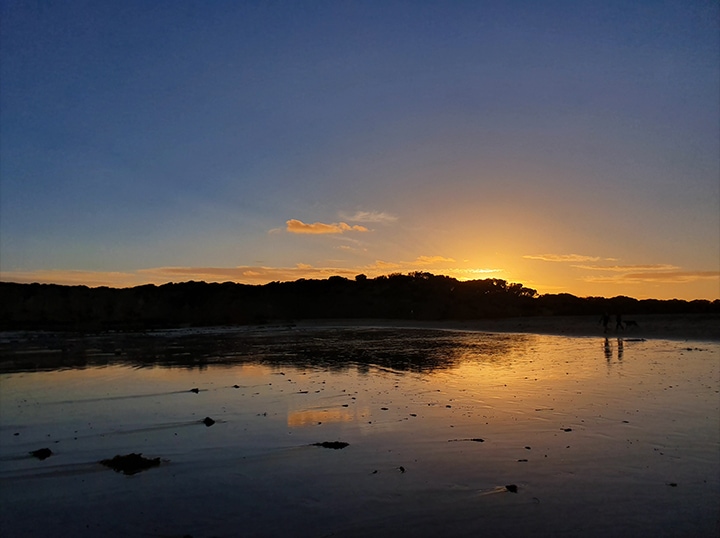 Photo réalisée avec le Galaxy S10 plus d’un lever de soleil derrière les montagnes se reflétant sur une étendue d’eau.
