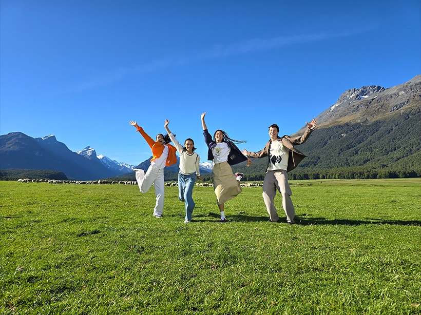 Foto de um campo aberto e montanhas com figuras perto do horizonte tirada com zoom de 1x.