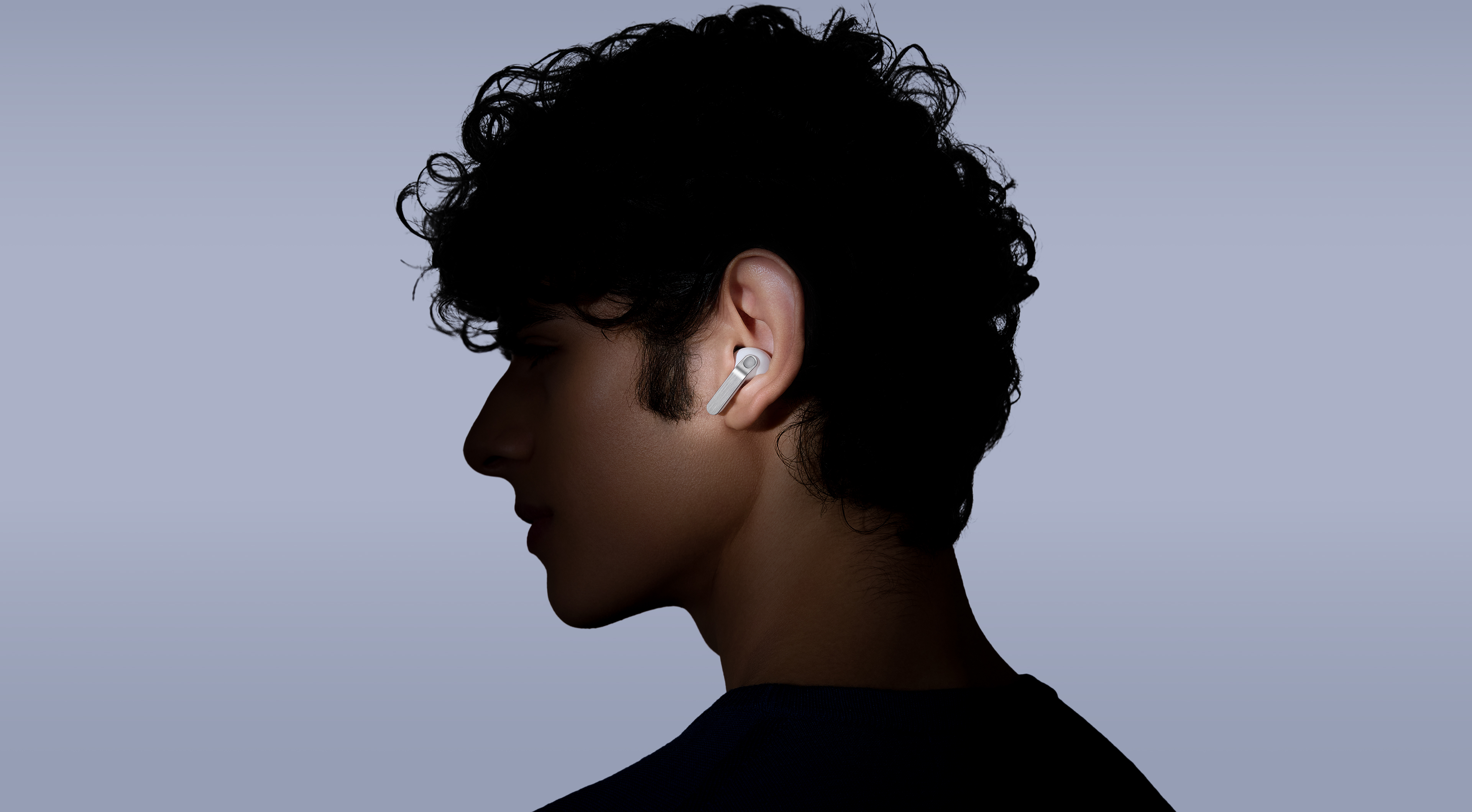 Una persona usa Galaxy Buds4 Pro mientras mira hacia la izquierda.