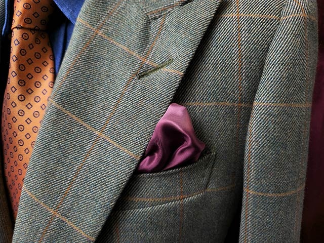 Primer plano de una chaqueta de traje con un pañuelo en el bolsillo delantero. Las líneas de la tela son distintivas y los colores son intensos gracias a Detail Enhancer.