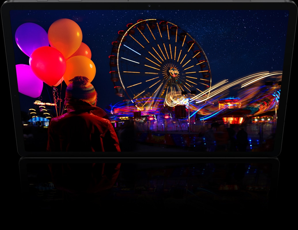 Ecranul afiseaza o imagine de noapte dintr-un parc de distractii, cu focuri de artificii care se extind dincolo de ecran