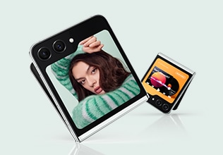 Man sieht ein zusammengeklapptes Galaxy Z Flip5 Gerät, auf einer Ecke stehend. Auf dessen Hauptdisplay ist das Foto einer Frau zu erkennen. Im Hintergrund sieht man ein weiteres zusammengeklapptes Galaxy Z Flip5 Gerät, auf einer Ecke stehend. Auf dessen Hauptdisplay ist eine Musik-Playlist zu erkennen.