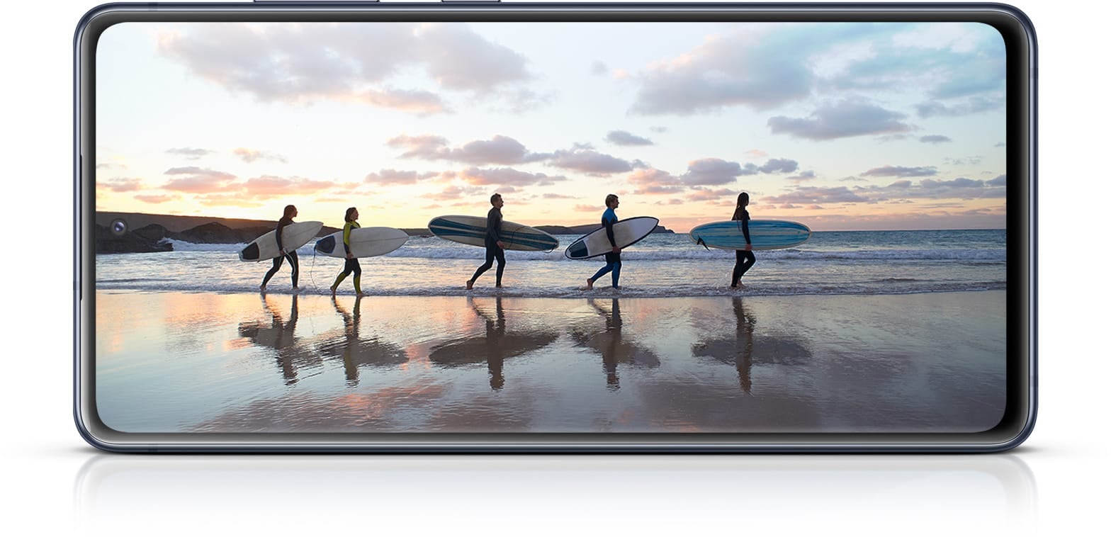 Galaxy S20 FE mit einem Foto von Surfern im Meer, um die eindringliche Erfahrung des Infinity-O Displays zu verdeutlichen.
