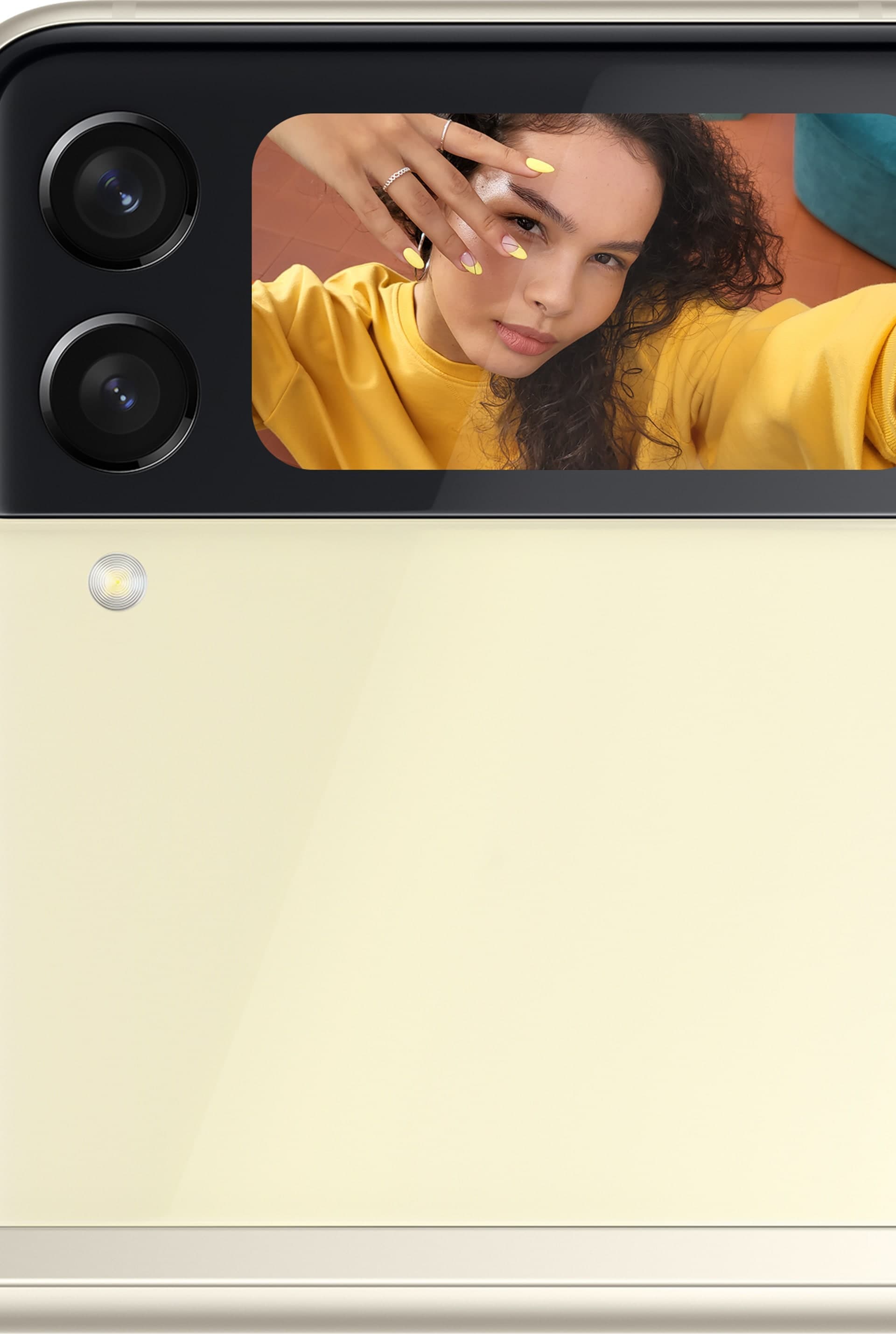 Die Vorderseite eines Galaxy Z Flip3 5G mit einer Frau, die ein Selfie aufnimmt, das auf dem Frontdisplay zu sehen ist.