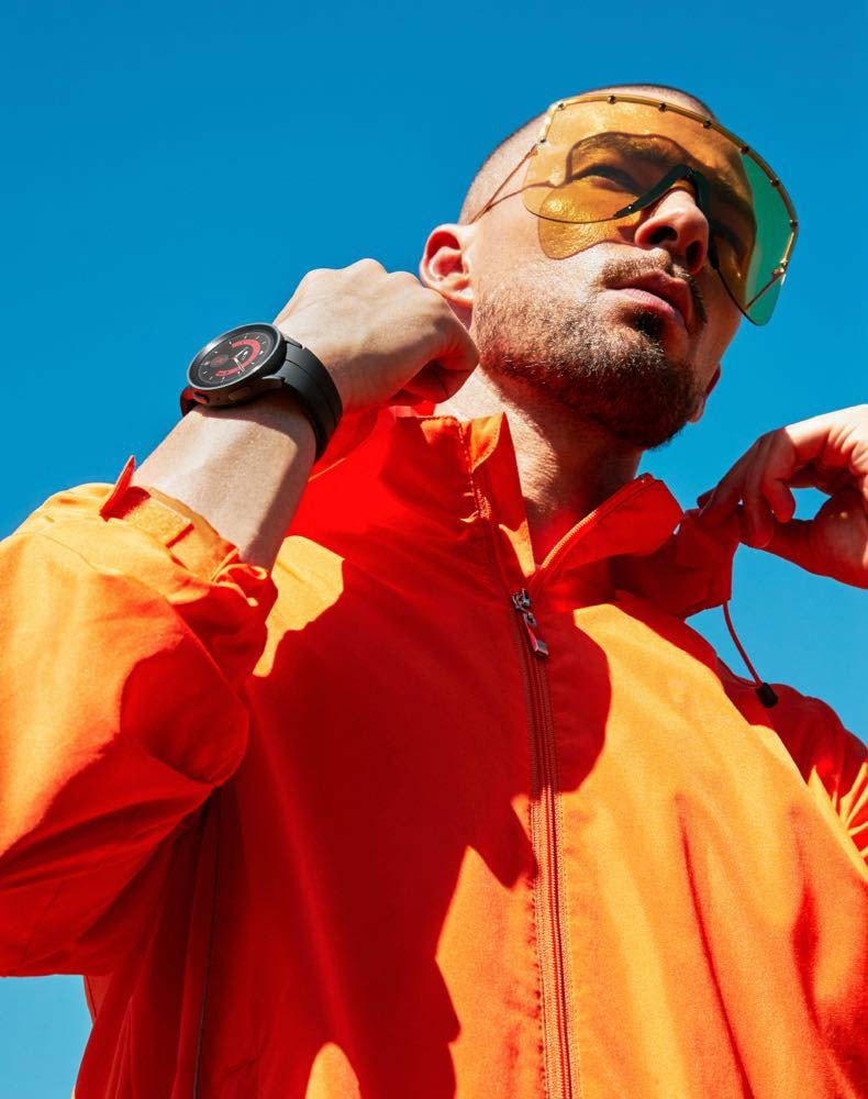 Image of a man in a bright orange jacket posing outdoors, wearing a Watch5 Pro on his wrist.