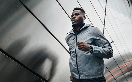 Un hombre corre al aire libre mientras lleva un dispositivo Galaxy Watch4 Classic.