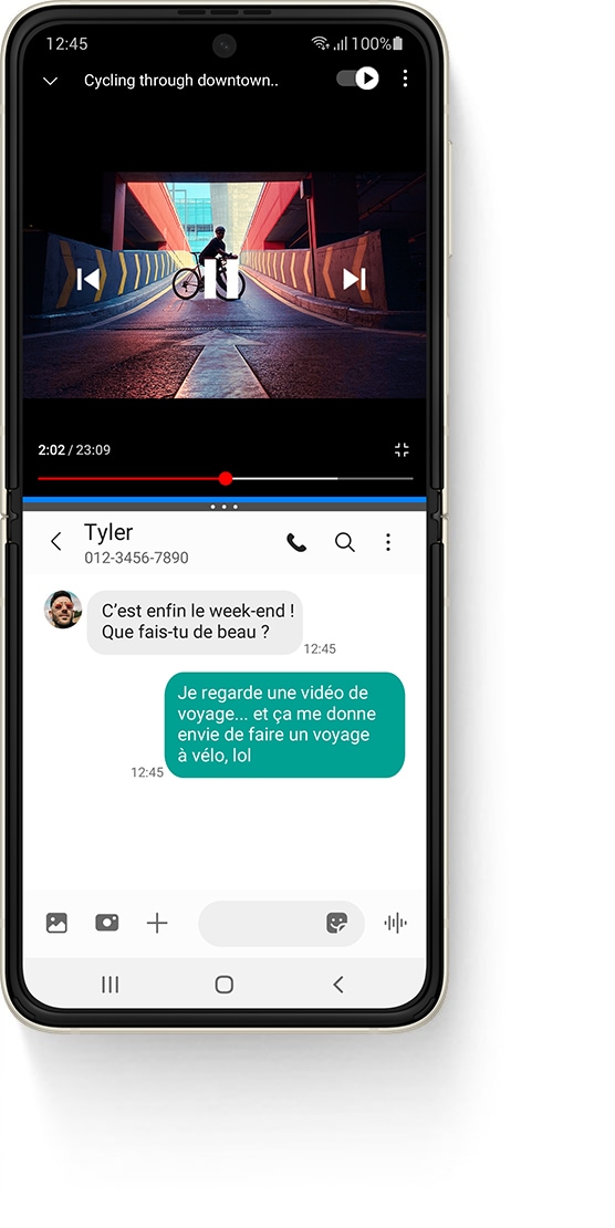 Galaxy Z Flip3 5G déplié en fenêtre multi-active, avec une vidéo YouTube en haut, une vidéo intitulée Vélo en centre-ville et une personne debout sur un vélo, sur une rampe. On peut lire, dans l’application Messages en bas, le SMS de Tyler disant « Enfin le week-end ! Tu fais quoi ? ». Le message de réponse dit « Je regarde une vidéo de voyage… et maintenant j’ai envie de faire du vélo, lol ».