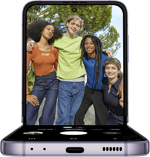 Galaxy Z Flip4 FlexCam, kamera hajlított módban. A főképernyőn a kamera alkalmazása fut, amely egy csoport képét mutatja, lentről. Ezt követően egy csapat barát pózol egy fényképhez. Előttük a kép készítéséhez használt FlexCam, hajlított kamera módba kapcsolt Galaxy Z Flip4 készülék fekszik a földön. A Hajlított mód használatával a szereplők a fénykép előnézeti képét látják a főképernyőn.
