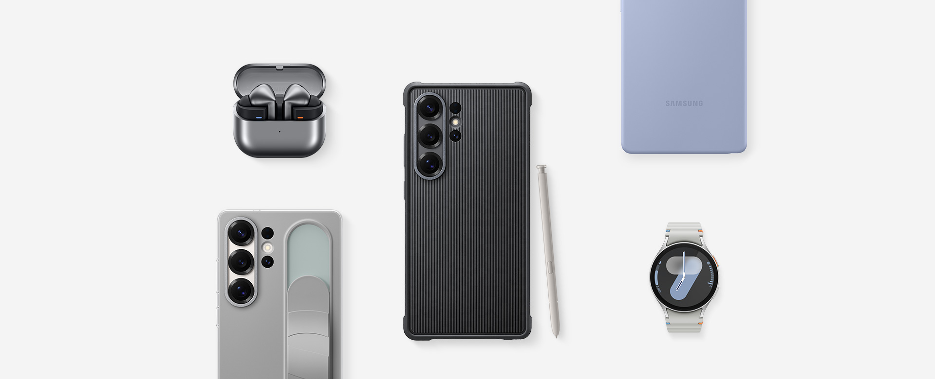 A flat lay of Samsung accessories for Galaxy S25 Ultra: First, Galaxy Buds3 Pro in Silver with the ear buds, Galaxy S25 Ultra with Rugged Case installed and S Pen in Light Gray, Galaxy S25 Ultra with Silicone Case in Light Blue installed, Galaxy Watch7, Galaxy S25 Ultra with Standing Grip Case in Gray installed.