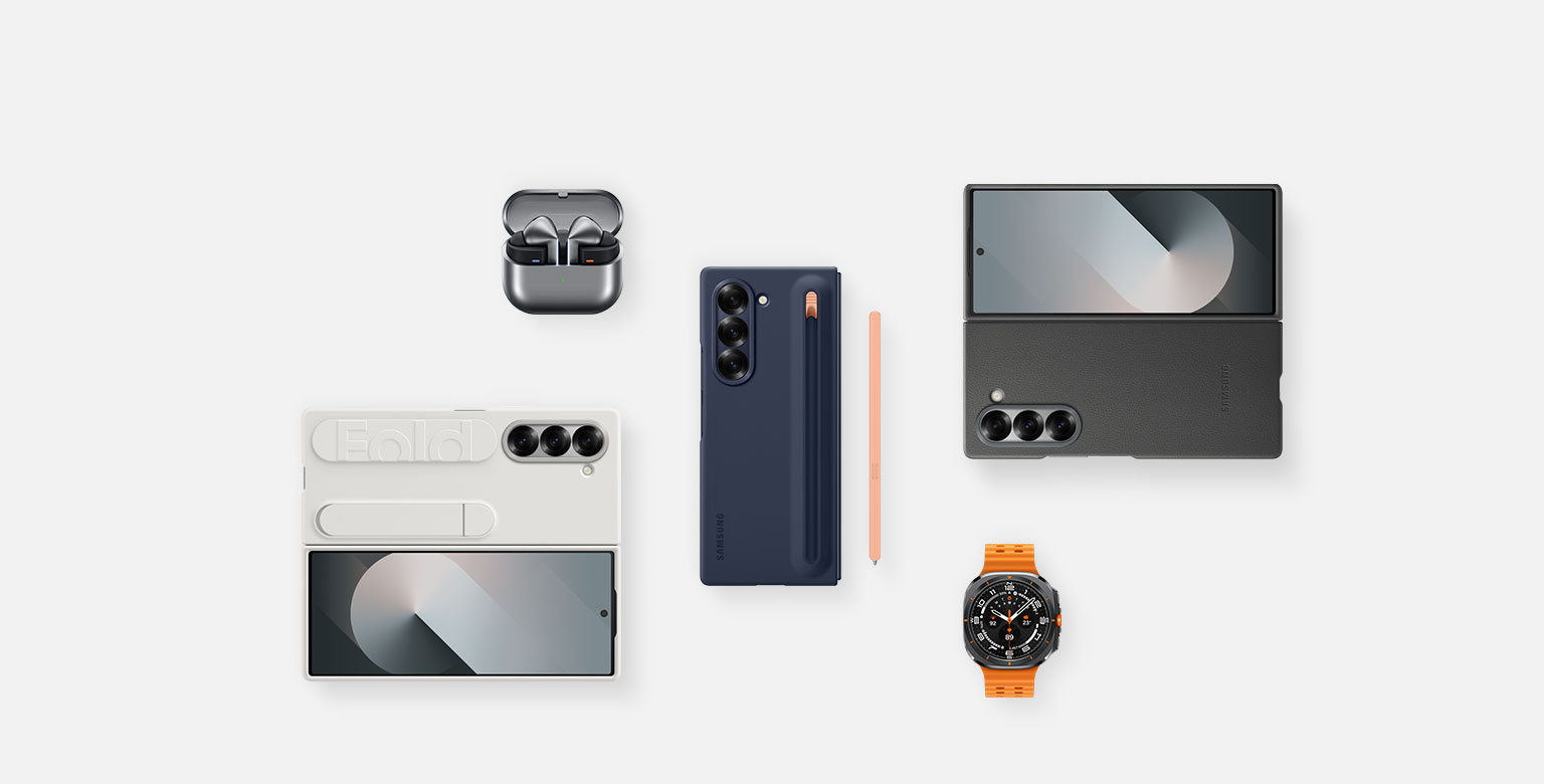 A flat lay of accessories for Galaxy Z Fold6: Galaxy Buds3 Pro in Silver with the buds case open and the ear buds in place, Galaxy Z Fold6 with the S Pen Case in Navy installed with S Pen in Pink to the side, Galaxy Z Fold6 with the Kindsuit Case in Grey installed, Galaxy Watch Ultra in Titanium Grey and Galaxy Z Fold6 with the Silicone Case in White installed.
