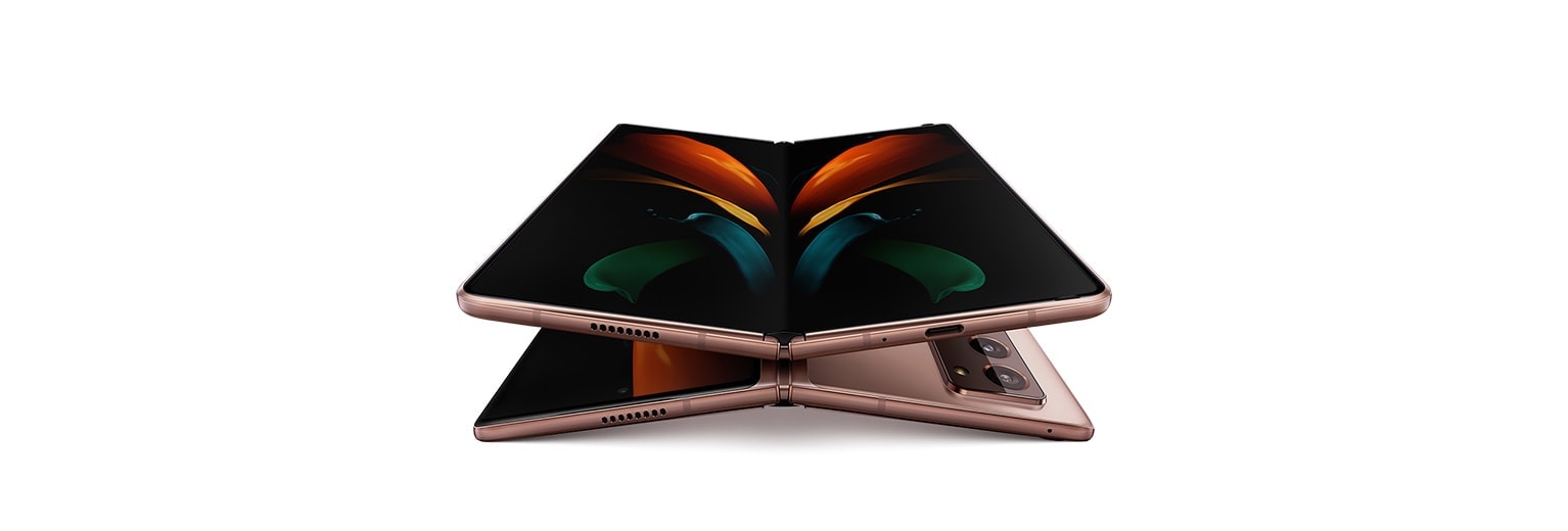 שני טלפונים מסוג Galaxy Z Fold2 פתוחים בגוון ברונזה, אחד שוכב עם הפנים כלפי מעלה והשני שוכב עם הפנים כלפי מטה. הטלפון שמוצג מקדימה נמצא מעל הטלפון ששוכב עם הפנים כלפי מטה, ומציג את טפט הפרפר הגרפי על המסך.