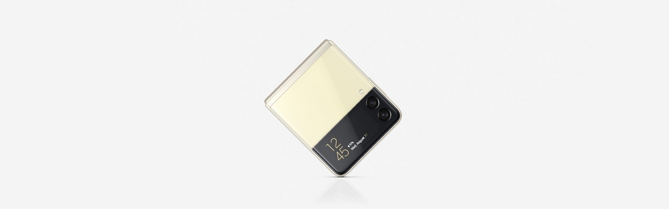 A folded Cream Galaxy Flip3 is placed upright on the screen with it's corner touching the ground.