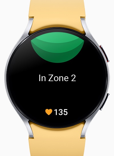 يمكن رؤية Galaxy Watch6 وهي تعرض شاشة منطقة HR مخصصة، مع النص "In Zone 2" في المنتصف والرقم 135 بجوار أيقونة القلب في الأسفل.