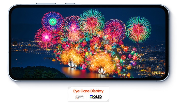Vibrant fireworks display over a night cityscape, viewed on a Galaxy A55 5G in landscape mode. With an 'Eye Care Display' and OLED technology logo under the phone.