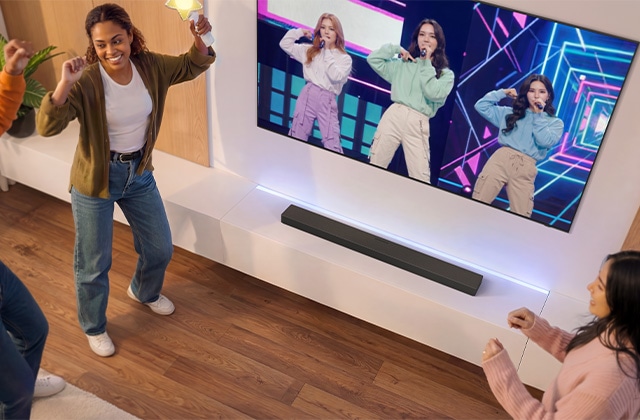 Friends dancing in front of a TV