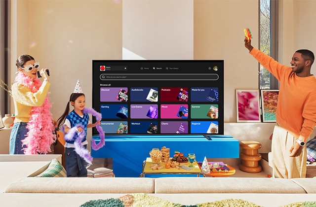 Family singing karaoke in front of a TV