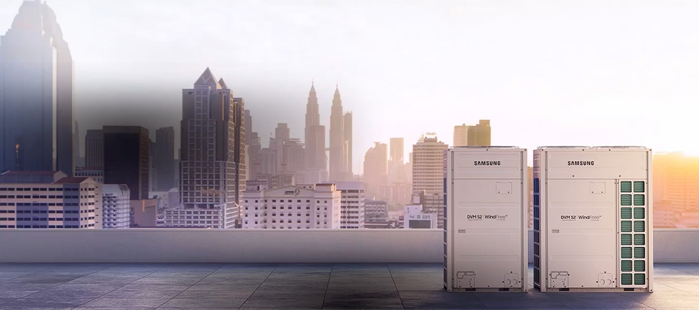 Two different sized Samsung Windfree DVM S2 units are installed on the rooftop of a building, with skyscrapers rising in the background.