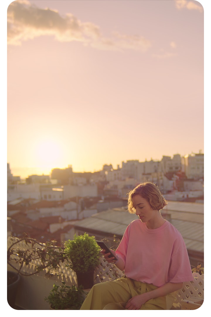 فتاة مع هاتف سامسونج على سطح بناية