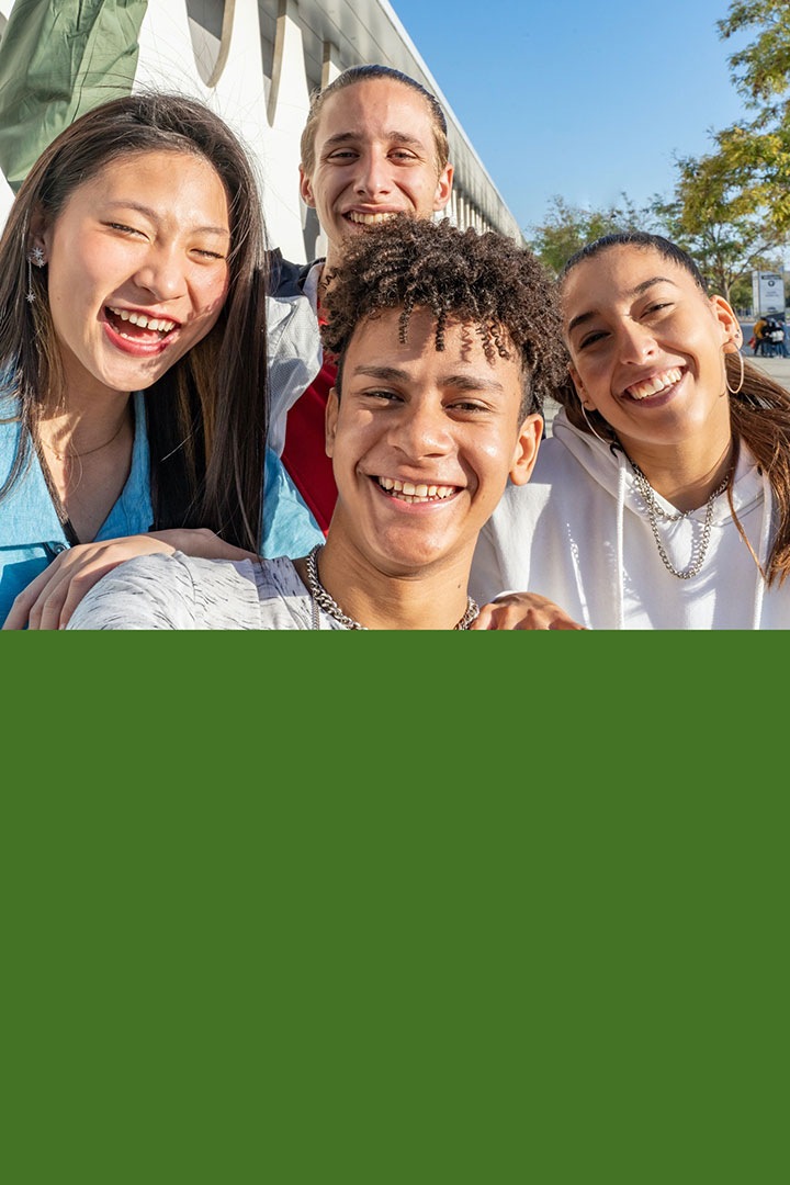 أربعة طلاب يبتسمون للكاميرا