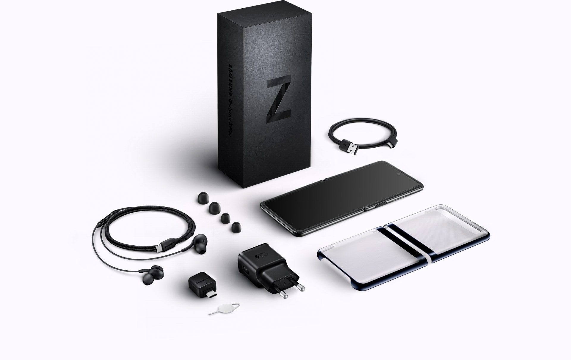 A flat lay of the items included in box with Galaxy Z Flip. The packaging, the device, a Clear Cover, the USB Type-C cable, travel adapter, headphones, earbud tips, USB connector, and a SIM tray ejector.