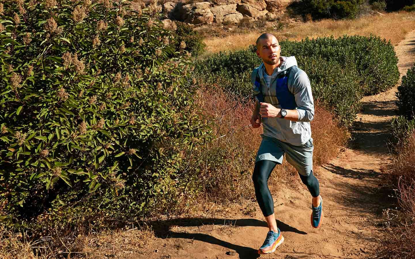 Un homme faisant une randonnée en descente avec une Watch5 Pro au poignet. La fonction de navigation y est affichée.
