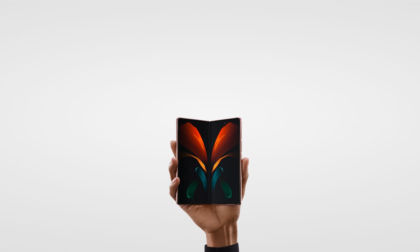 Une main tenant un Galaxy Z Fold2 Bronze Mystique légèrement plié, vu de face.